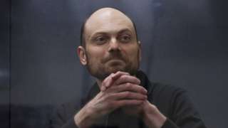 Jailed Russian opposition figure Vladimir Kara-Murza gestures as he stands behind a glass wall of an enclosure for defendants during a court hearing to consider an appeal against his prison sentence, in Moscow, Russia July 31, 2023.