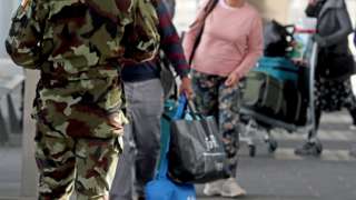 Members of the defence forces direct passengers arriving at Dublin Airport from one of 33 high-risk countries who will be transported to a mandatory 12-day hotel quarantine on Friday 26 March