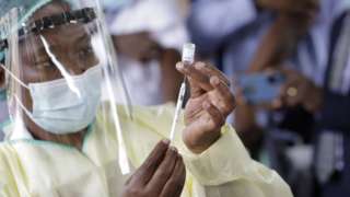 A health official collects a swab from a person on the first day of Covid-19 vaccination, at Wilkins Hospital in Harare, Zimbabwe, 18 February 2021.