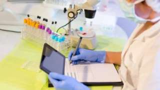 Scientist analyses samples in lab