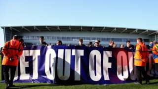 Oldham fans protest on the pitch