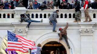 Rioters climb the outside of the US Capitol