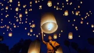 Un moine avec des lampes