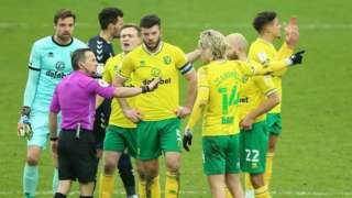 Norwich's players surrounded referee Keith Stroud following his decision to send off Emi Buendia