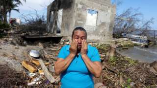Celia Figarola cries in front of what is left of her house as rising sea levels are destroying homes built on the shoreline and forcing villagers to relocate, in El Bosque, Mexico