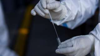 A health worker holds a Covid-19 swab stick