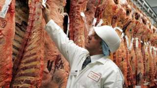 Butcher inspecting meat