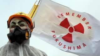 Anti nuclear protester holding Remember Fukushima sign in UK