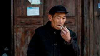Male Chinese farmer smoking a cigarette
