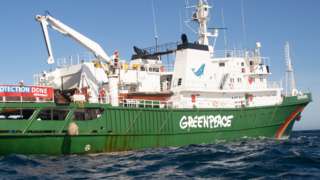 Greenpeace ship dropping a boulder into the sea