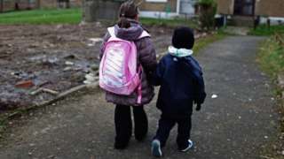 Children walk through a housing estate