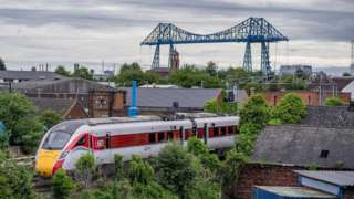 Azuma train travels with Transporter Bridge in the background