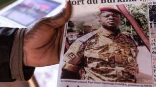 A man buys a newspaper with theh the picture of Paul-Henri Sandaogo Damiba the leader of the mutiny and of the Patriotic Movement for the Protection and the Restauration (MPSR) in Ouagadougou on January 25, 2022
