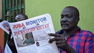 A man reads a copy of the Juba Monitor, with a heading referring to the killing of South Sudanese journalist Peter Moi of The New Nation newspaper, on August 21, 2015 in Juba