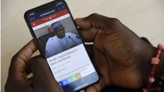 A journalist sources for information with a smartphone on the internet at the Arise News in Ikoyi neighbourhood in Lagos on June 10, 2021.