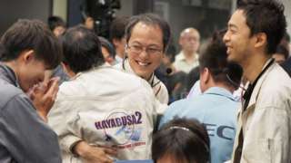 Researchers and employees celebrate after receiving confirmation of Hayabusa2's touchdown on the asteroid Ryugu