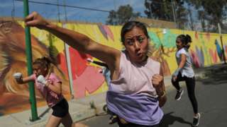 Women participate in a self-defense class on a street in Mexico City