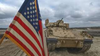 American flag in front of tank