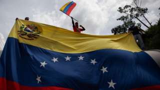 Homem balança bandeira da Venezuela