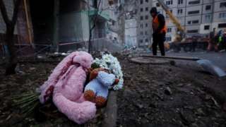 Игрушки и цветы у дома, разрушенного российской ракетой в Днепре