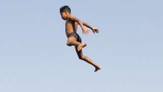 Children jump into the water of the Nile.