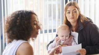 Mother with baby in interview - stock shot