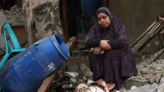 A woman sits on rubble of a building destroyed in Israeli bombardment following overnight rainstorms in Rafah in the southern Gaza Strip on November 15, 2023