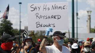 A protester holds a sign with Rayshard Brooks' name in Atlanta