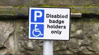 A UK parking sign saying 'disabled badge holder only'
