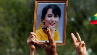 A person holds a picture of leader Aung San Suu Kyi