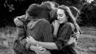 A group of siblings hugging in a portrait by Simon Bray