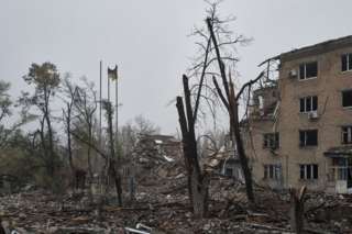 Charred trees, a lone Ukrainian flag and the remains of a destroyed building in Avdiivka, Ukraine