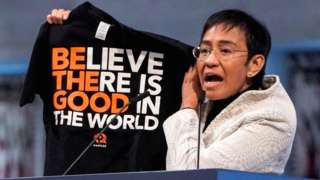 Nobel Peace Prize winner Maria Ressa shows a T-shirt while she delivers a speech during the Nobel Peace Prize award ceremony at the Oslo City Hall in Oslo, Norway