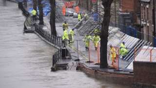 Environment Agency teams work on temporary flood barriers in the Wharfage area of Ironbridge, Shropshire