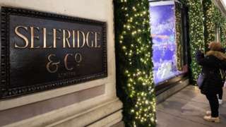 Customers take pictures of holiday displays at Selfridge. The British luxury store chain has been bought for $5.37bn
