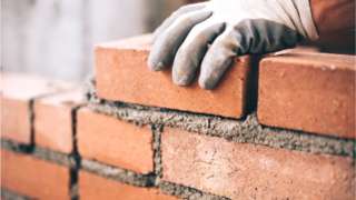 Construction worker lays bricks