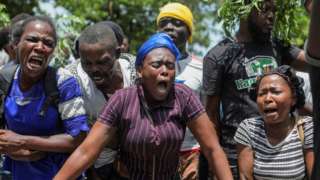 Haiti residents gather outside a military base demanding