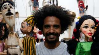 Mohamed Fawzy Bakkar, a 35-year-old Egyptian puppeteer poses for a photograph with his favorite puppets at his handmade puppet manufacturing workshop, amid the coronavirus disease (COVID-19) pandemic, in Cairo, Egypt May 29, 2021.