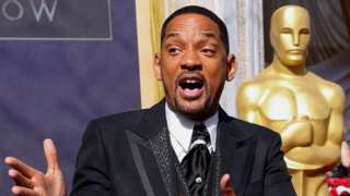 Will Smith in front of a giant Oscars statuette before the ceremony
