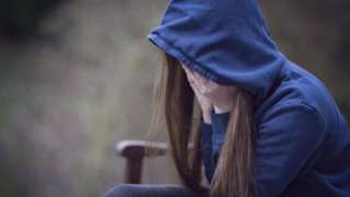 A teenage girl in a hooded top