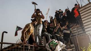 Protesters climb a fence as they gather near the Swedish embassy in Baghdad hours after the embassy was stormed and set on fire ahead of an expected Koran burning in Stockholm, in Baghdad, Iraq, July 20, 2023