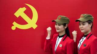This picture taken on April 21, 2016 in Shaoshan shows Chinese tourists posing in front a flag of the Communist Party of China