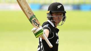 New Zealand batter Amy Satterthwaite raises her bat in celebration after hitting a century in the third ODI against England