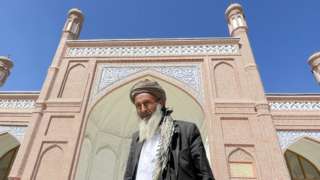A man standing outside Eid Gah mosque