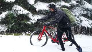 A cyclist wades through snow in Allenheads, in the Pennines, in Northumberland on 30 March 2022