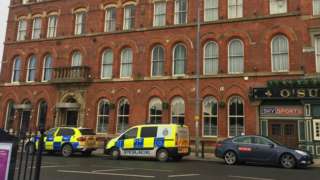 Two police vehicles parked outside the hotel