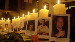 Photographs of the 26 Britons killed in the Bali bombings a year ago including that of Clive Walton (right) and Ed Waller (2nd right) stand beside candles lit in their memory by some of their relatives inside St Martin-in-the-Fields in central London, where a memorial service was held in remembrance of them.