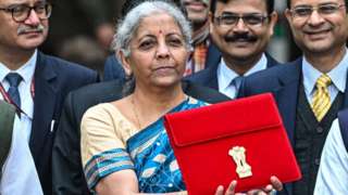 Nirmala Sitharaman, India's finance minister, center, leaves to present the budget at the parliament on Thursday