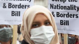 Woman in mask protests against the Nationality and Borders bill