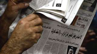 A man reads a newspaper in Bahrain
